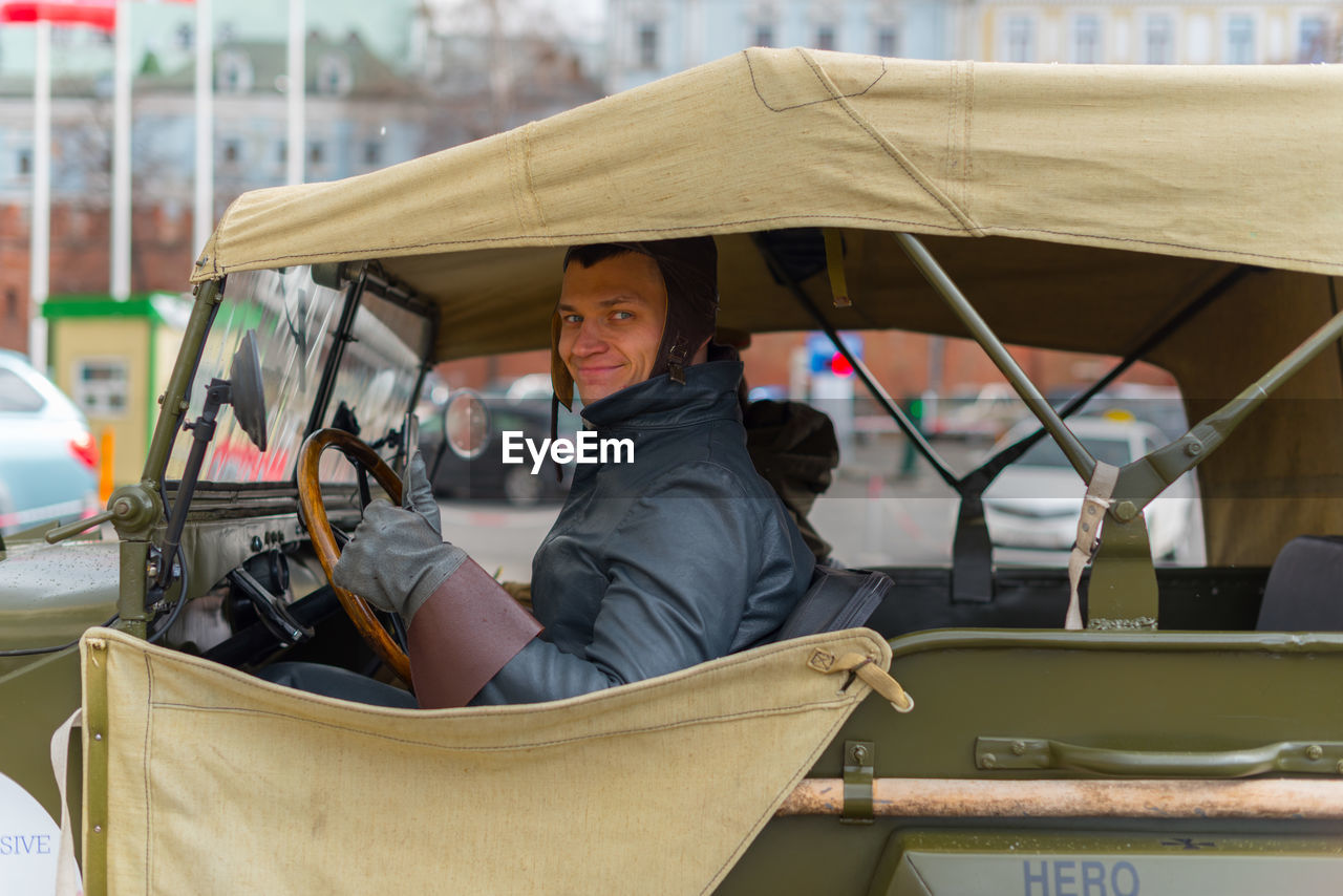 Portrait of man driving while sitting in car