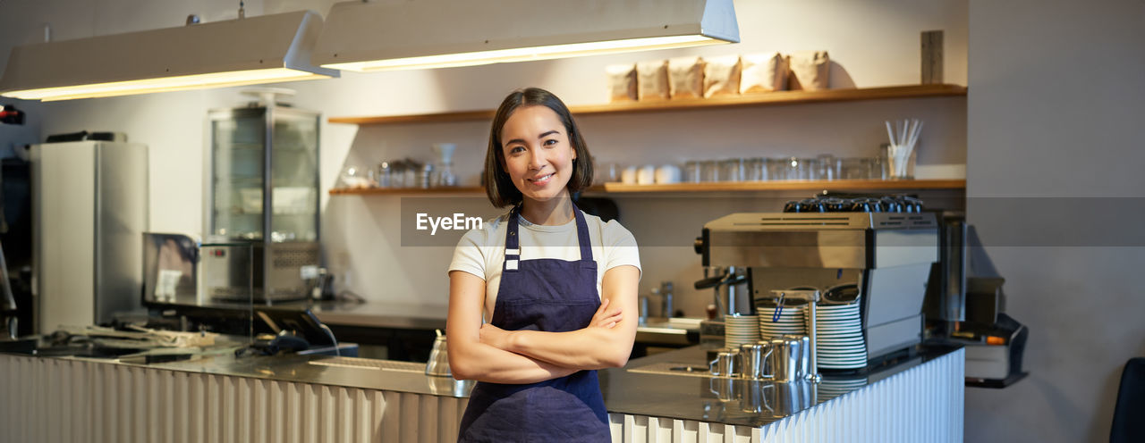 portrait of young woman standing in kitchen at home