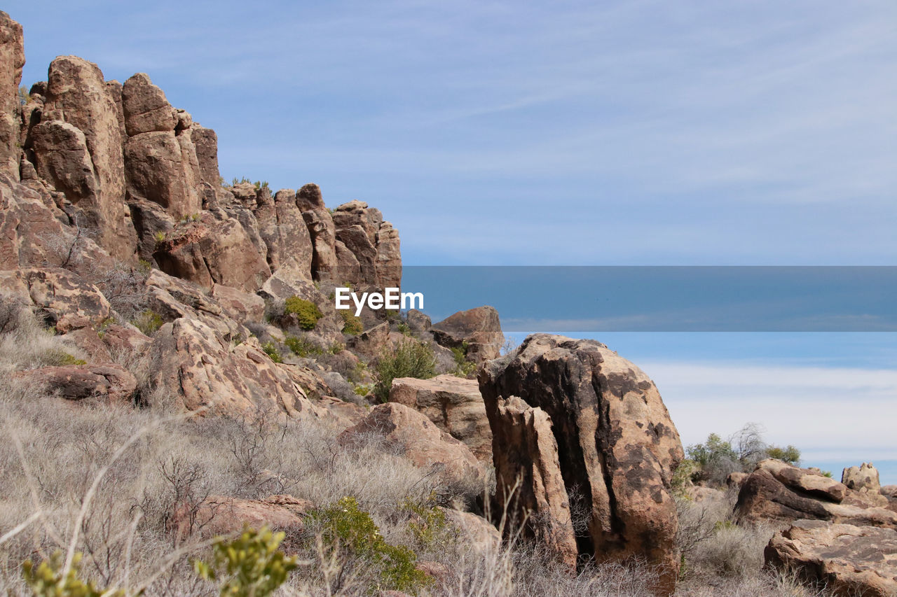 ROCK FORMATIONS ON CLIFF AGAINST SKY