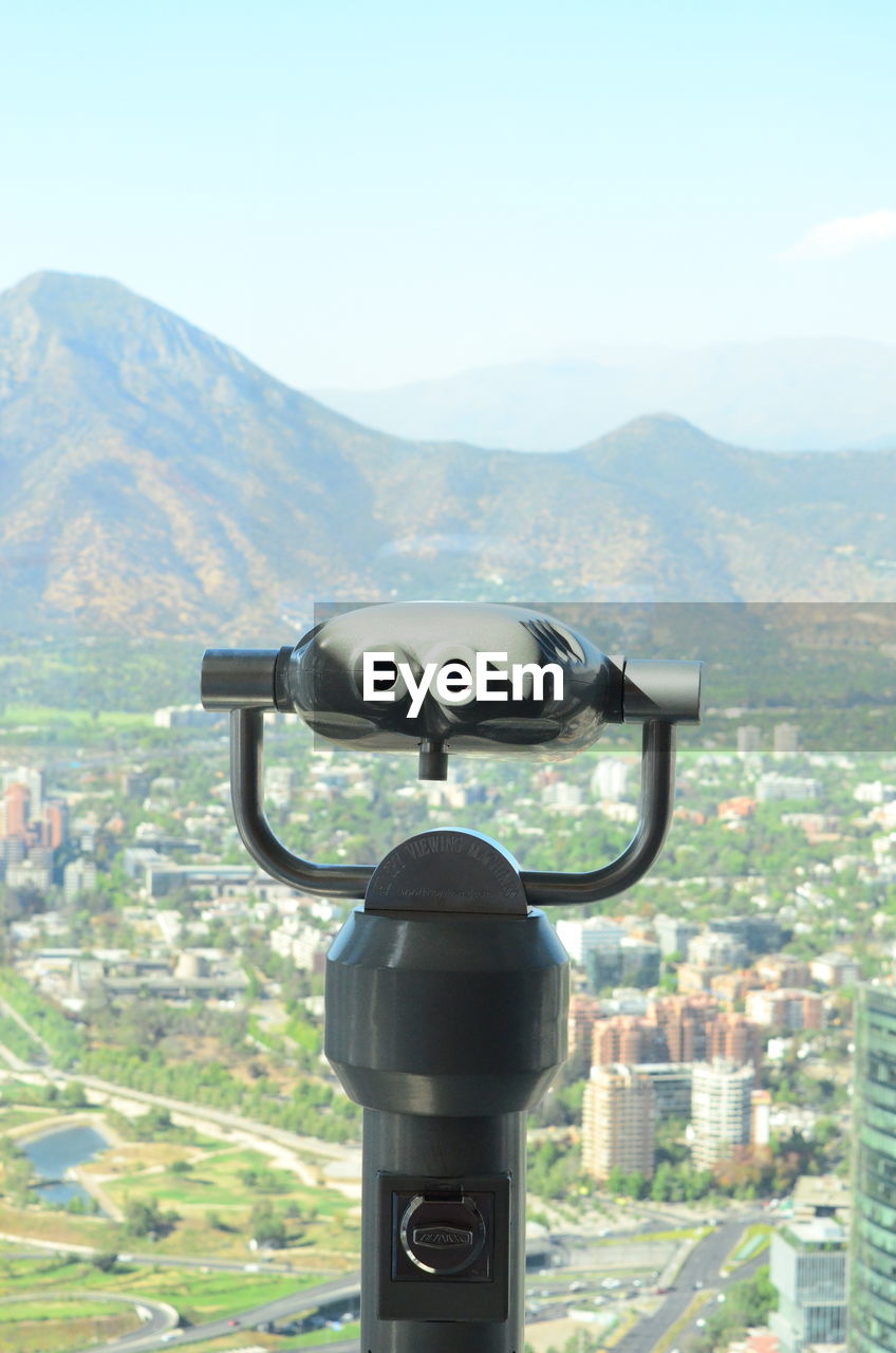 CLOSE-UP OF COIN-OPERATED BINOCULARS AGAINST SKY