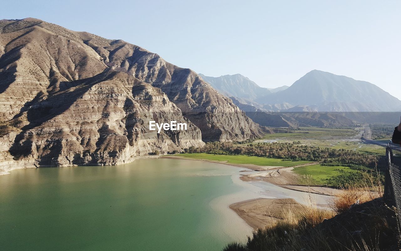 Scenic view of lake and mountains against clear sky