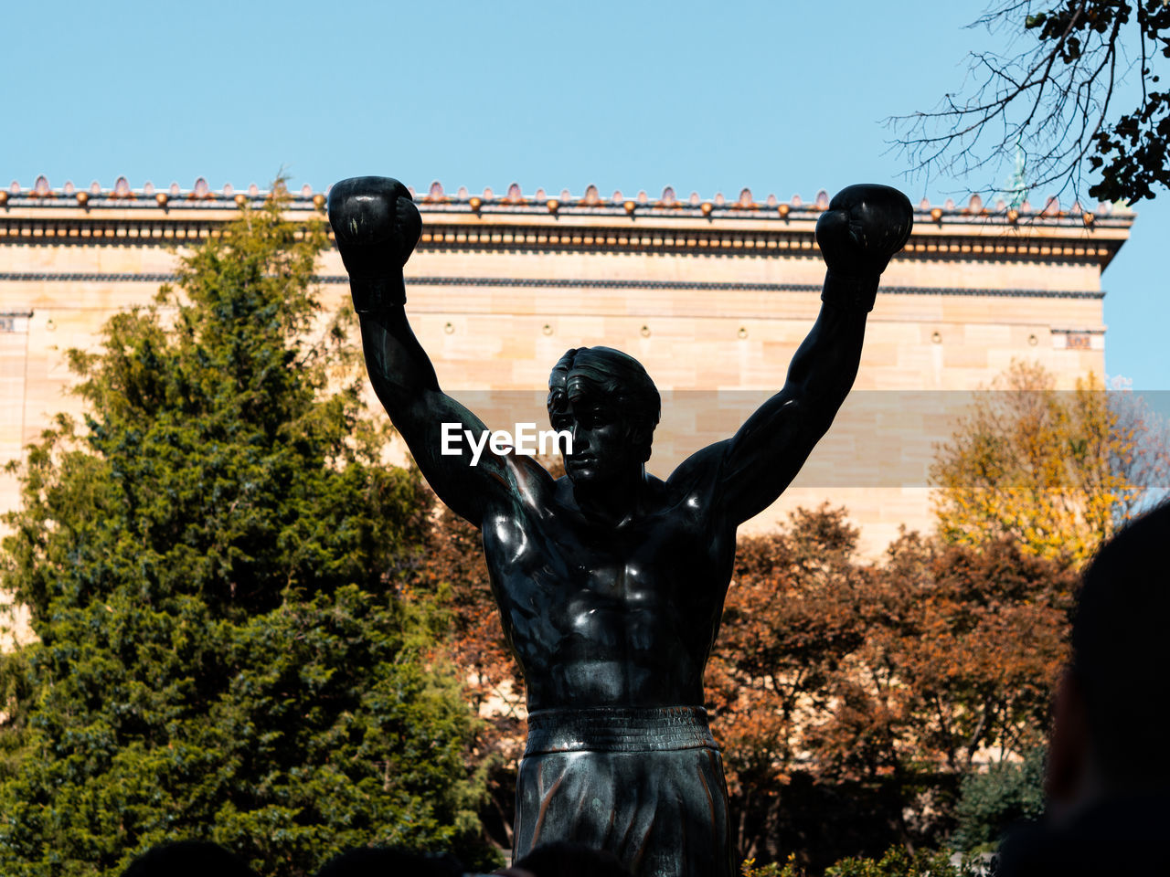 STATUE AGAINST CLEAR SKY AND TREES AGAINST PLANTS