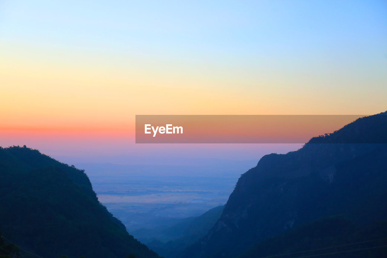 SCENIC VIEW OF MOUNTAINS AGAINST SKY DURING SUNSET