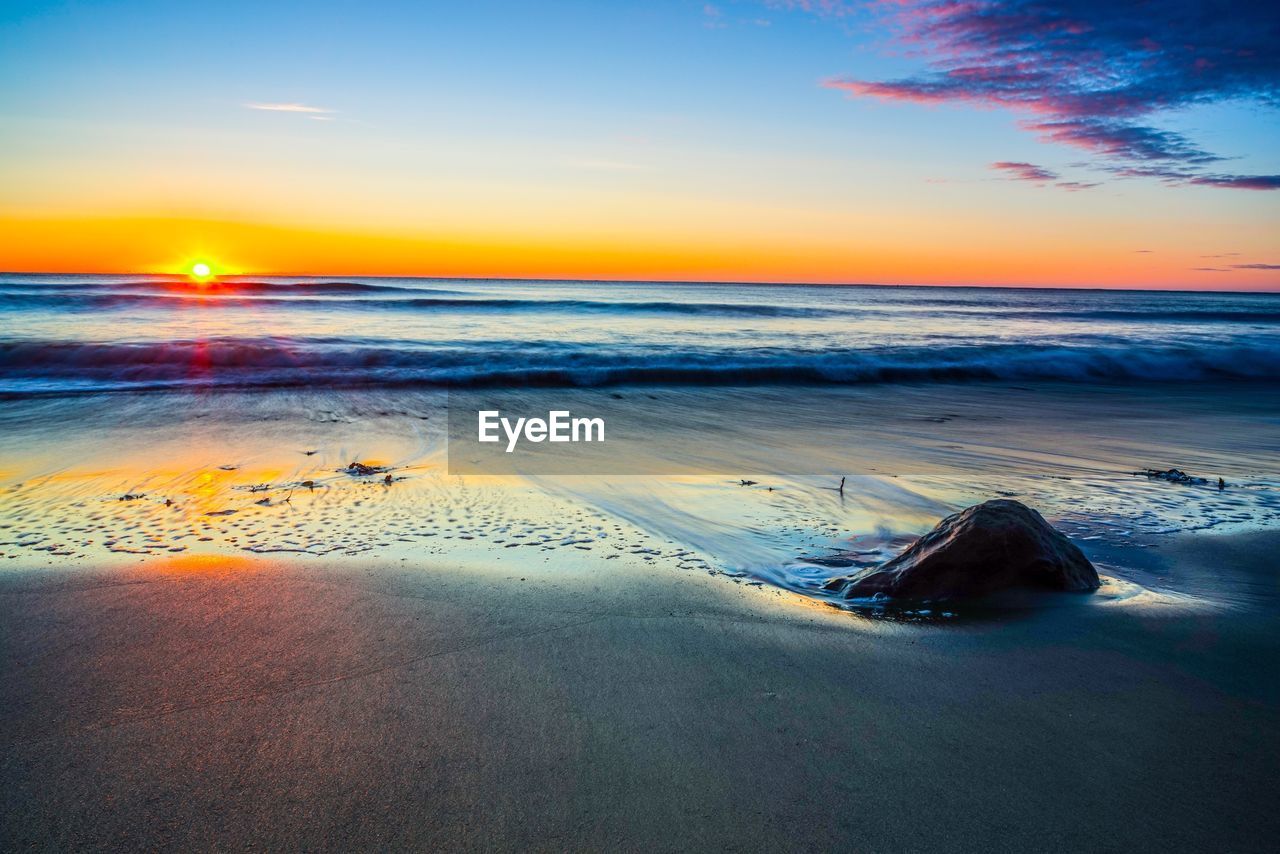 SCENIC VIEW OF BEACH DURING SUNSET