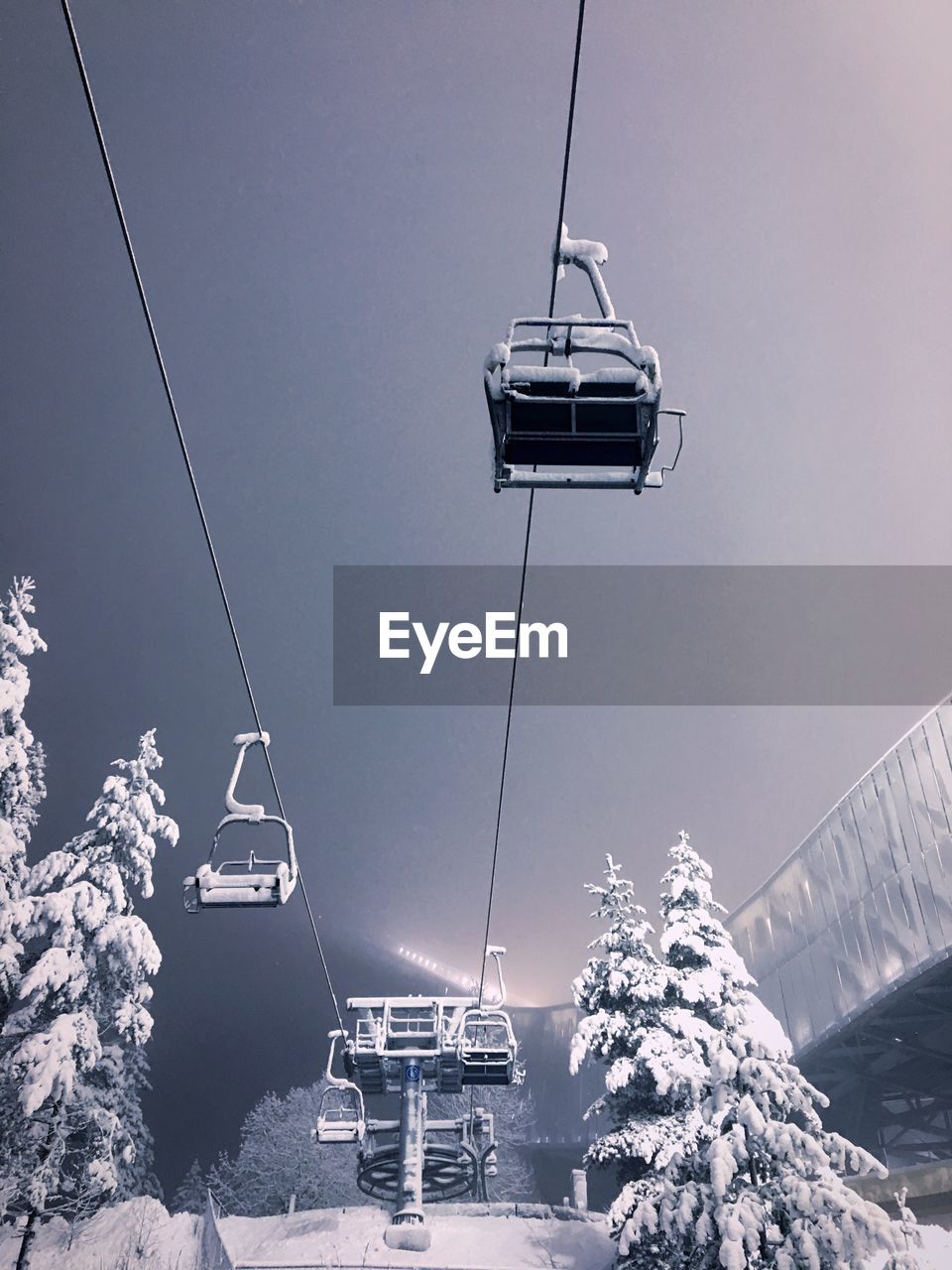 Low angle view of ski lift against sky during winter at night