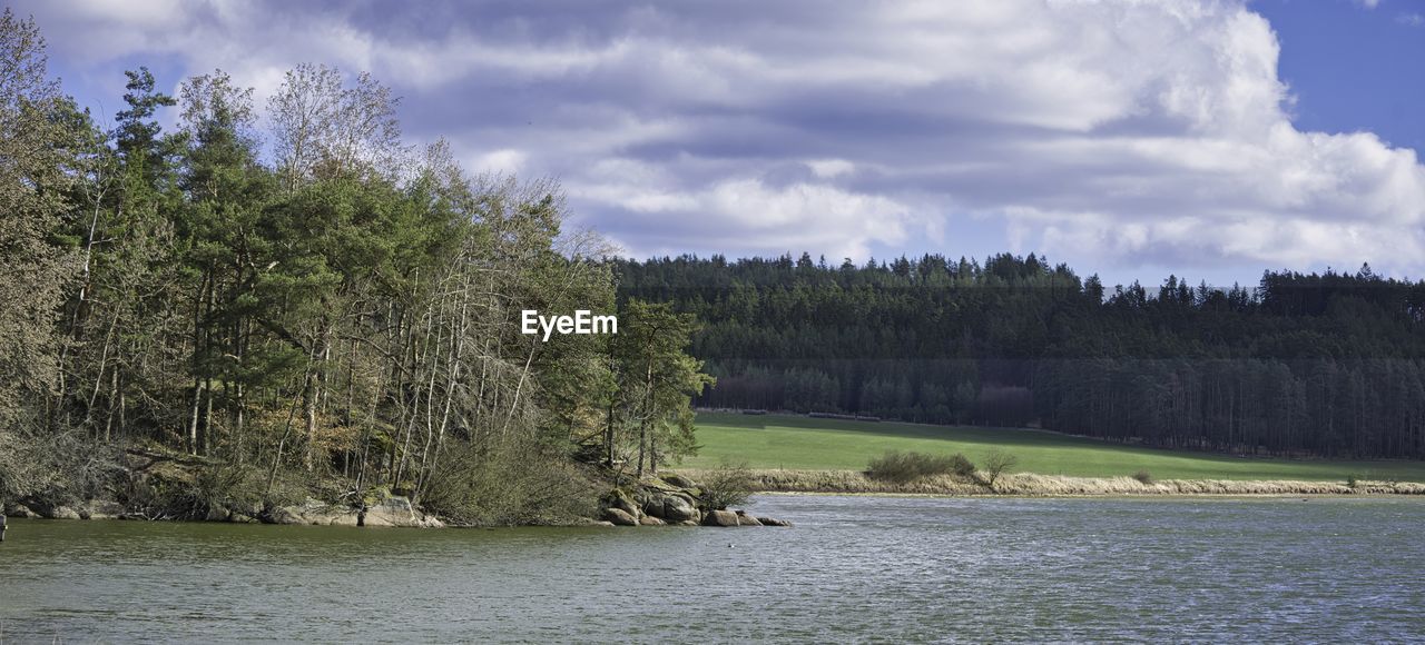TREES BY RIVER AGAINST SKY