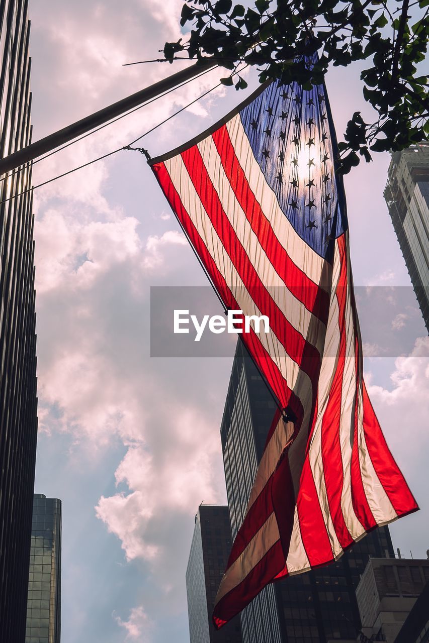 Low angle view of american flag hanging against sky