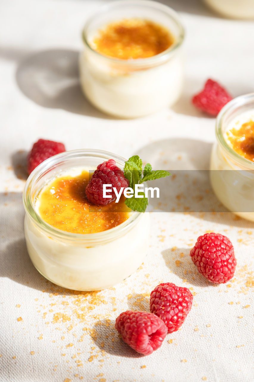 French dessert custard creme brulee with caramel crust, garnished with fresh berries. 