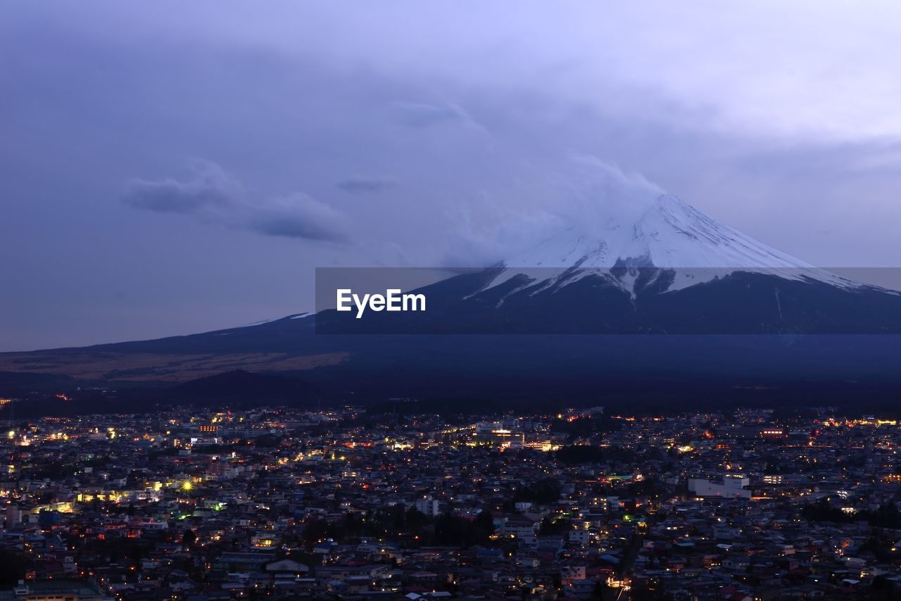 High angle view of illuminated cityscape by mount fuji at night