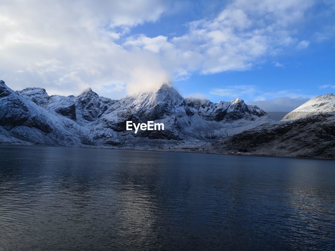Scenic view of lake and snowcapped mountains against sky