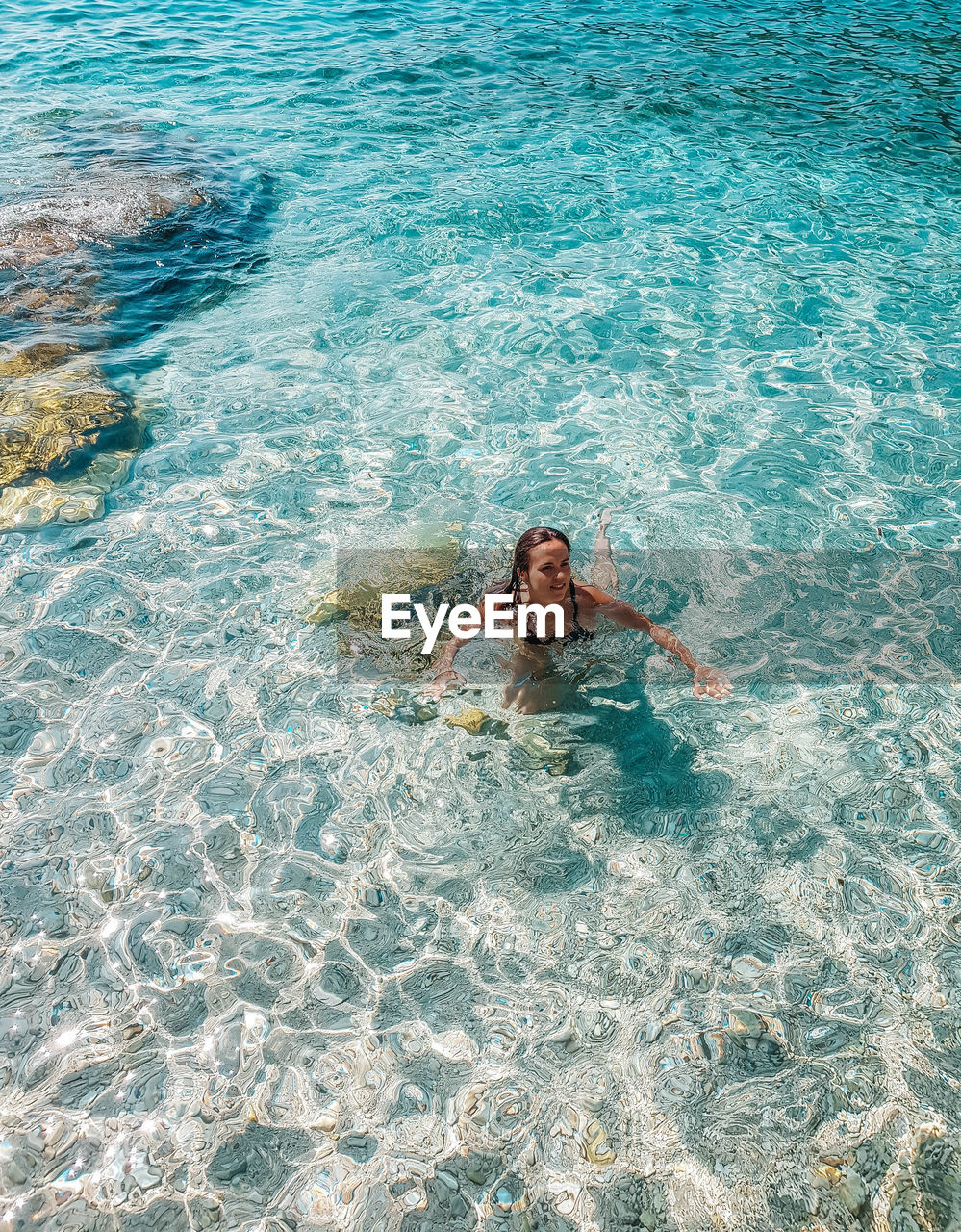 Young woman swimming in transparent water. sea, summer, beach.