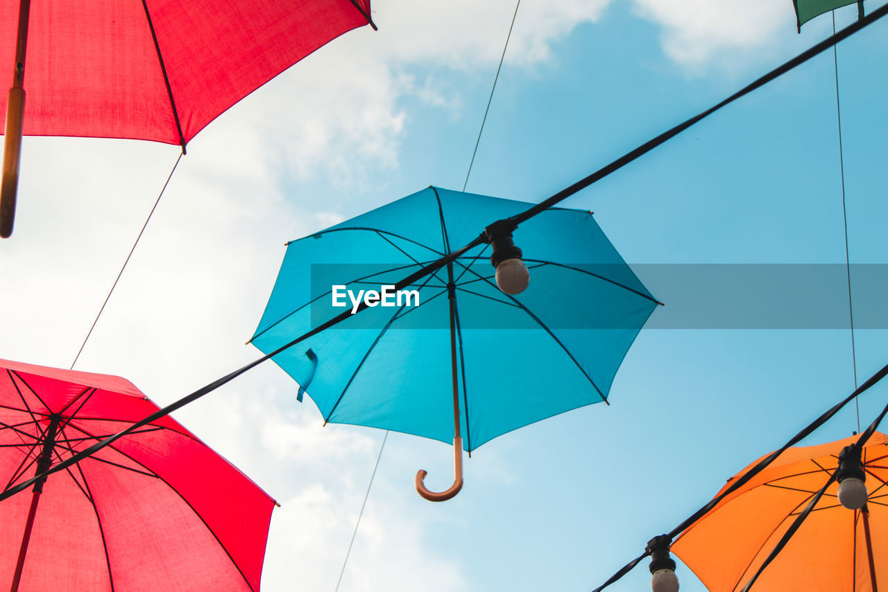 LOW ANGLE VIEW OF MULTI COLORED UMBRELLA AGAINST SKY