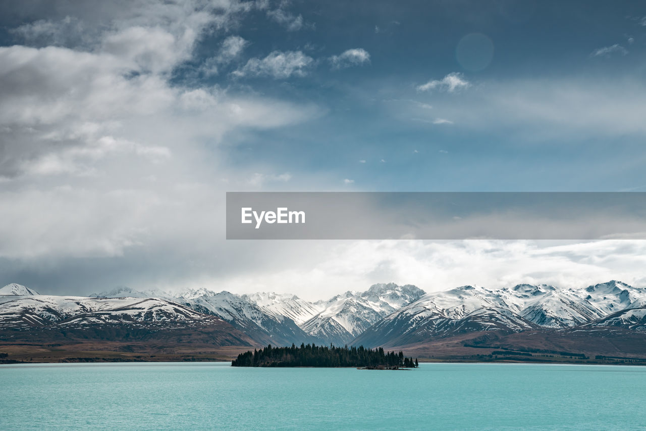 A scenic landscape of new zealand southern alps and lake tekapo with blue sky and clouds.