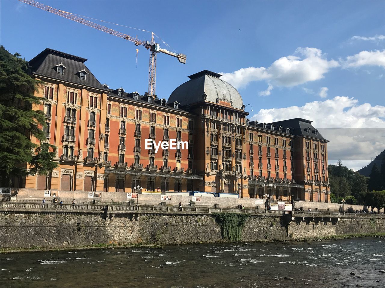 BUILDING BY RIVER AGAINST SKY