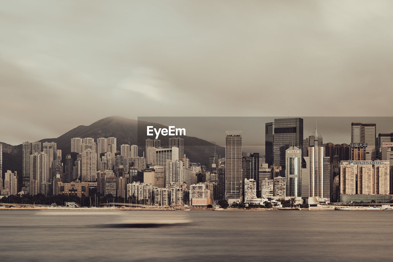 Buildings in city against cloudy sky