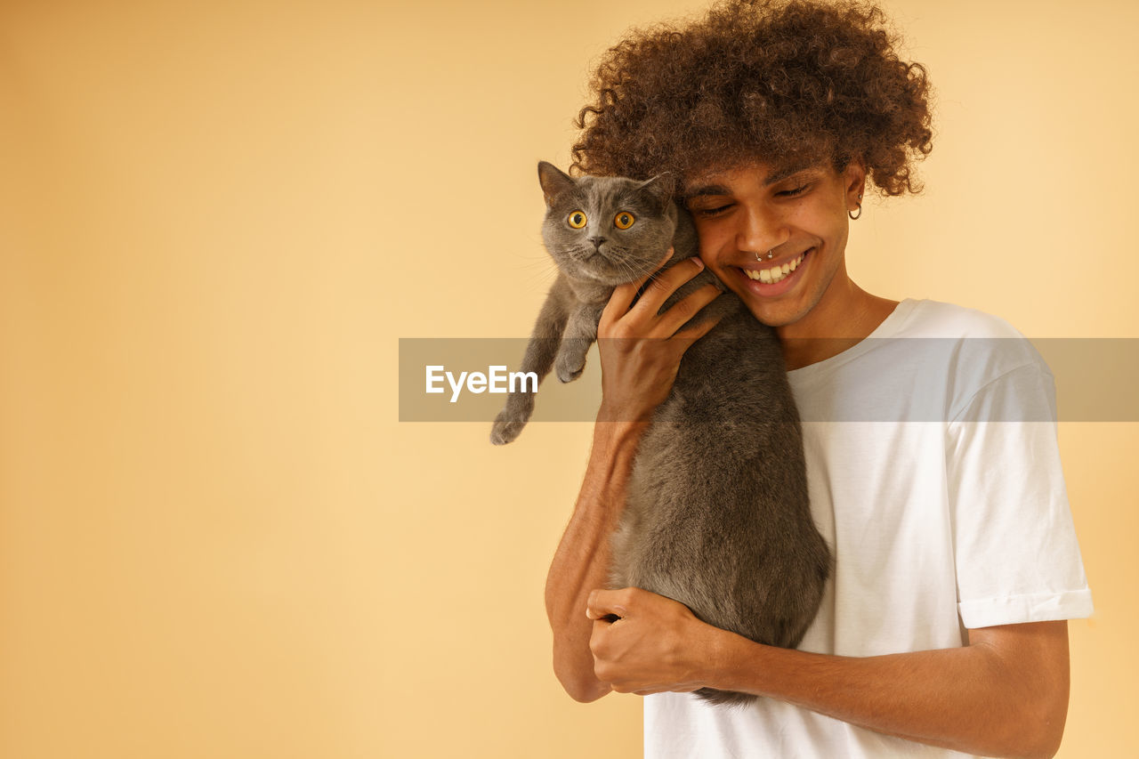 PORTRAIT OF A SMILING YOUNG WOMAN HOLDING CAT