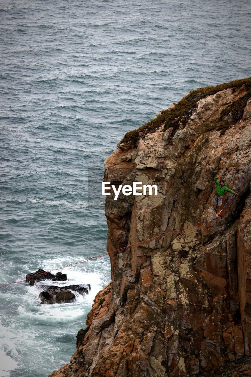 High angle view of man highlining against rock mountain