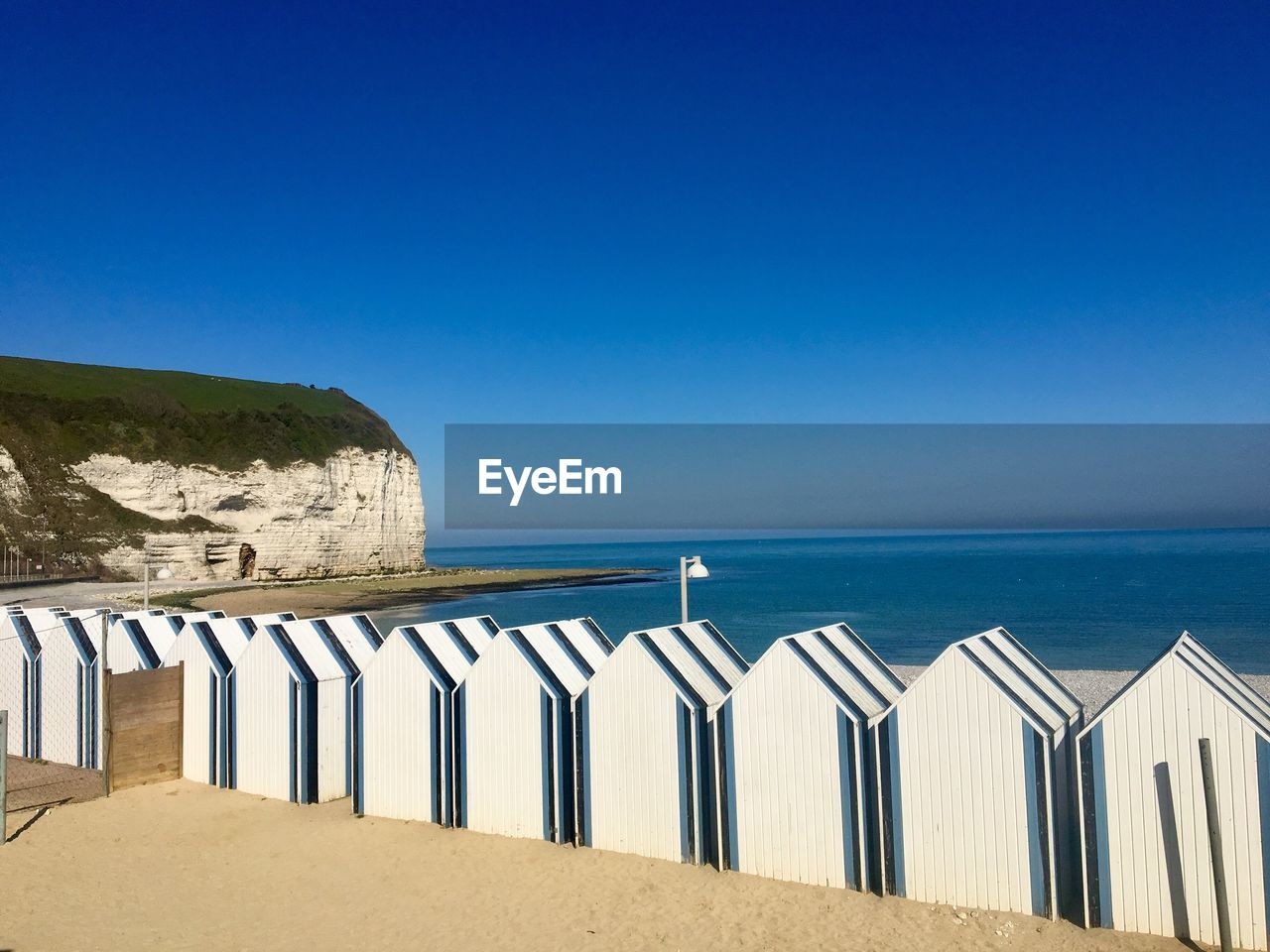 Scenic view of beach huts against blue sky 