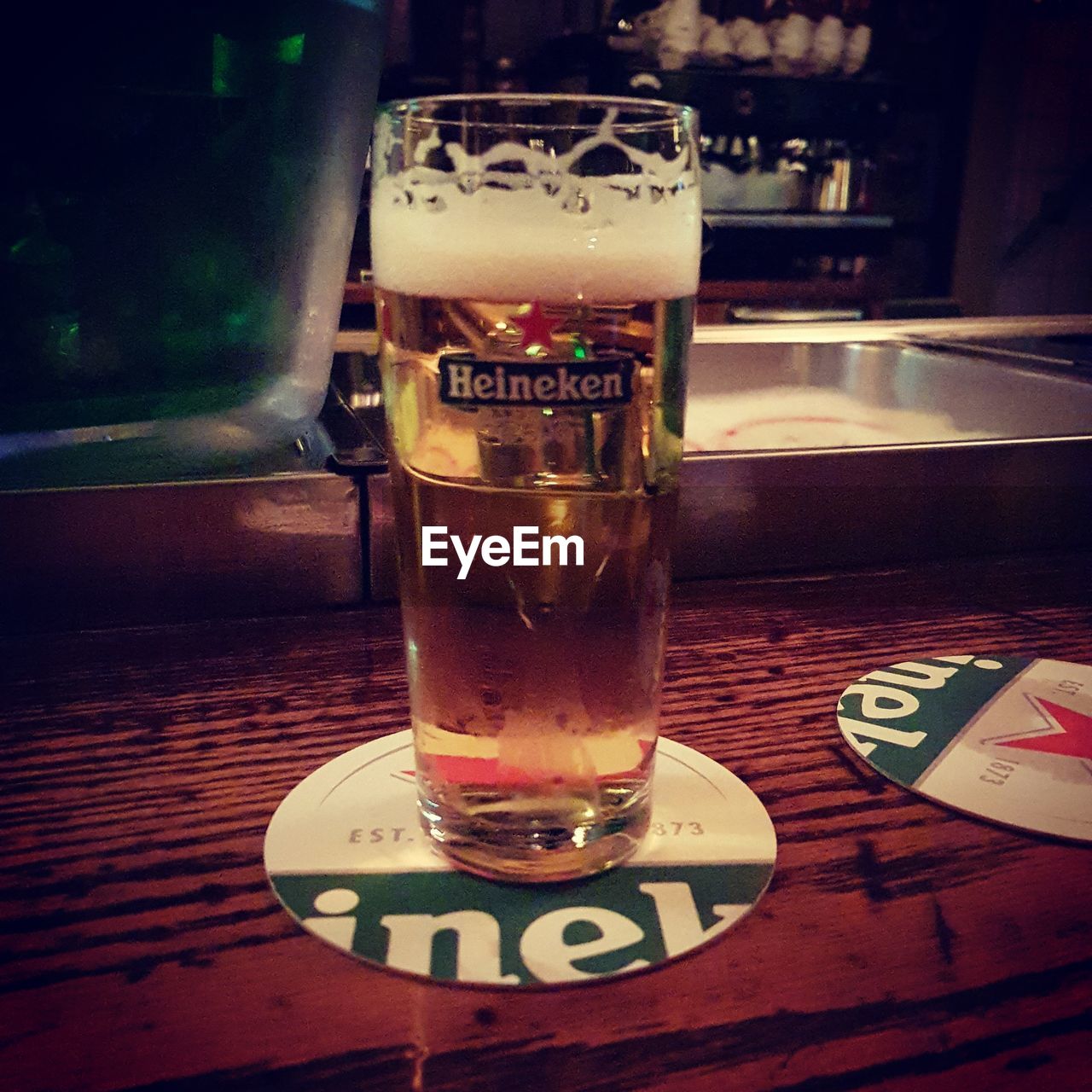 CLOSE-UP OF BEER GLASS ON TABLE AT BAR