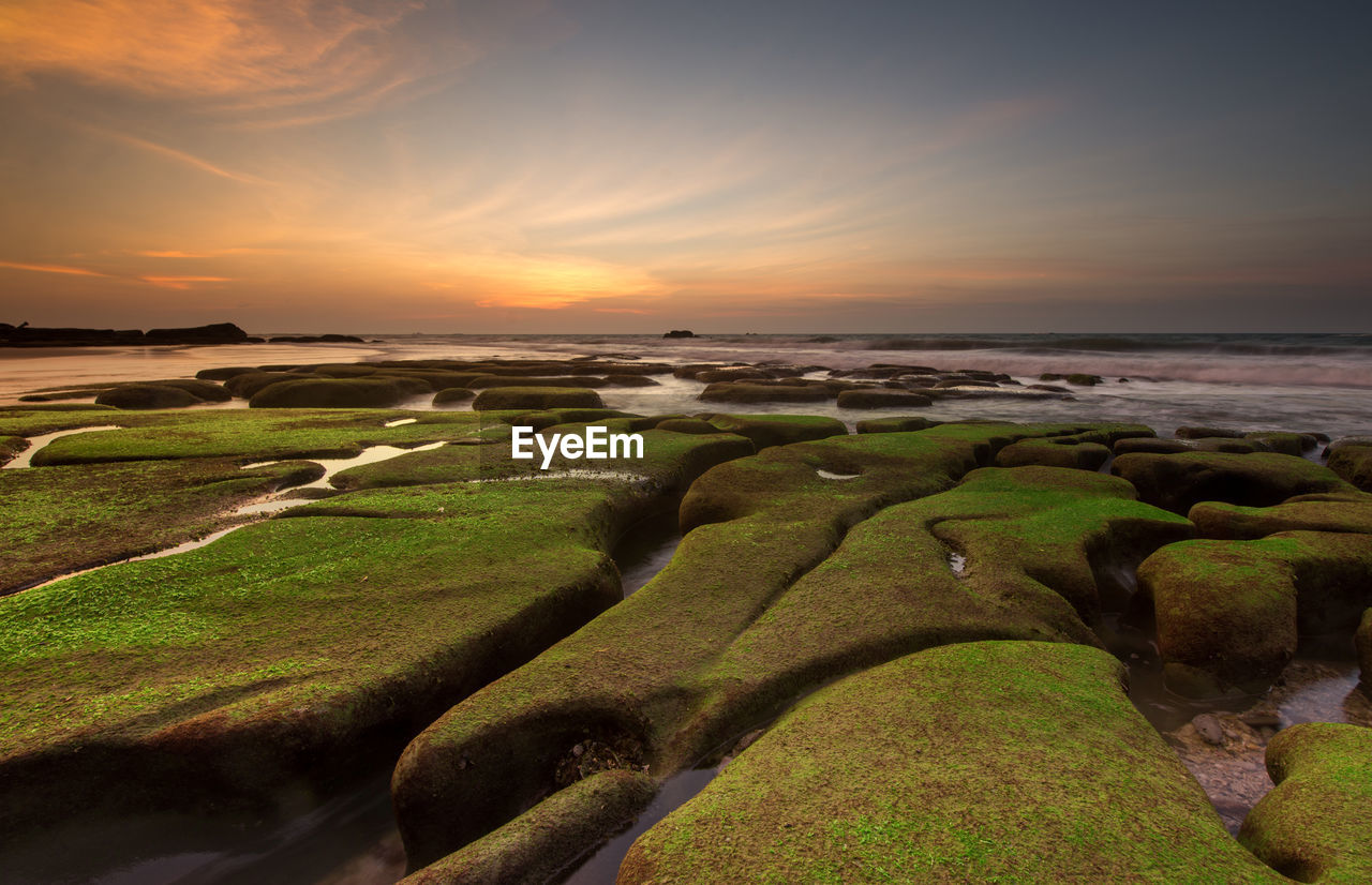 Scenic view of beach against sky during sunset