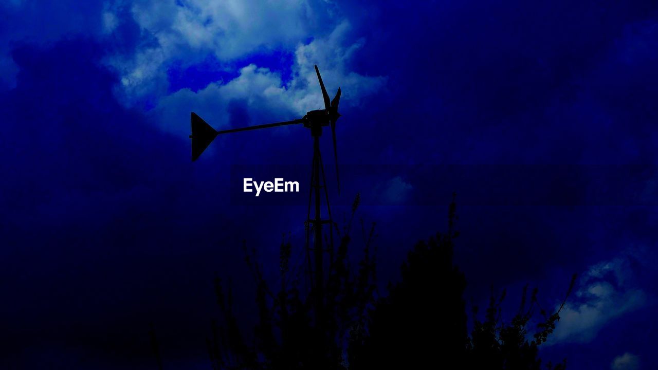 LOW ANGLE VIEW OF WINDMILLS AGAINST SKY AT NIGHT
