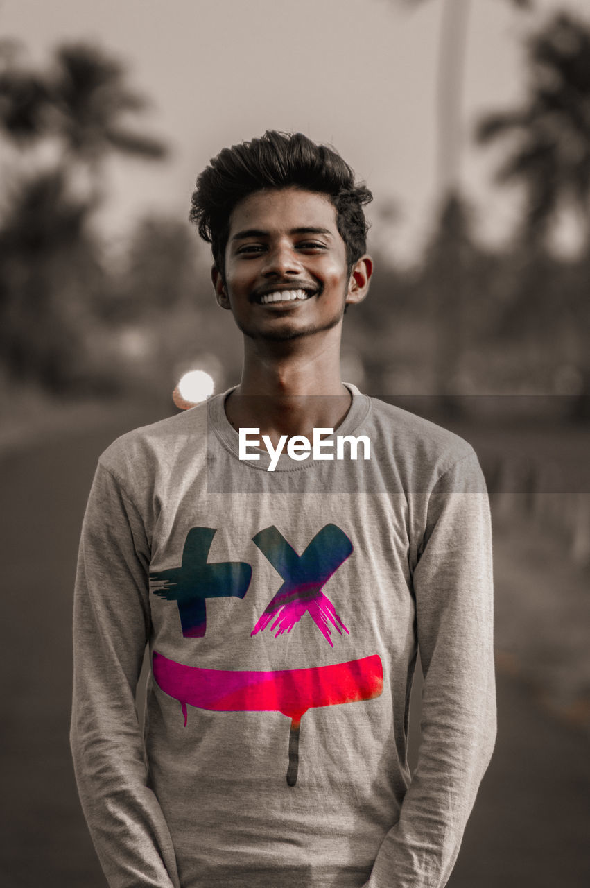 Portrait of smiling young man standing outdoors