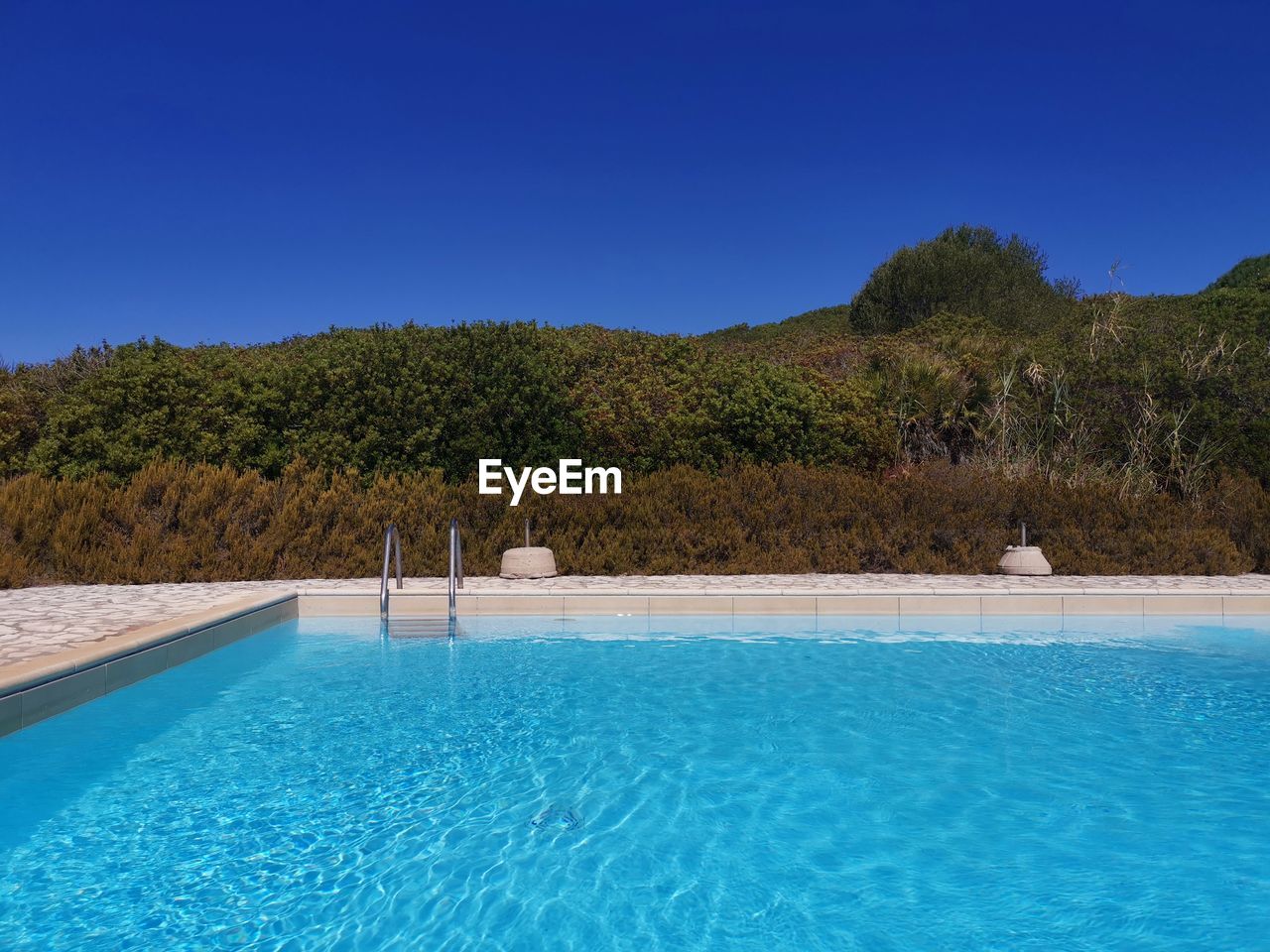 Scenic view of swimming pool against clear blue sky