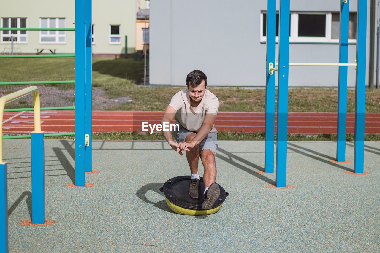 Professional athlete perform squat with his own weight on balance apparatus for more intense workout