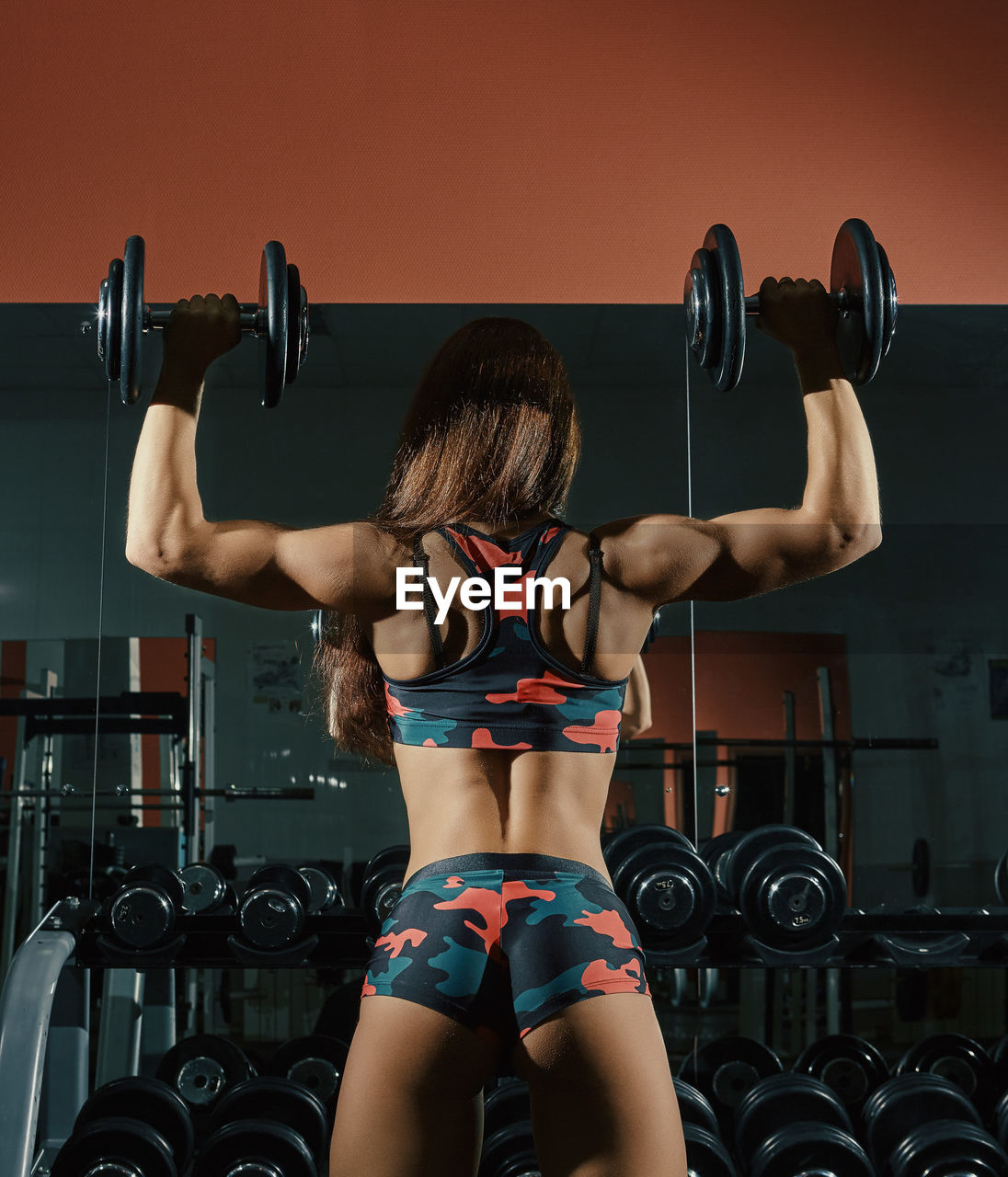 Rear view of young woman exercising in gym