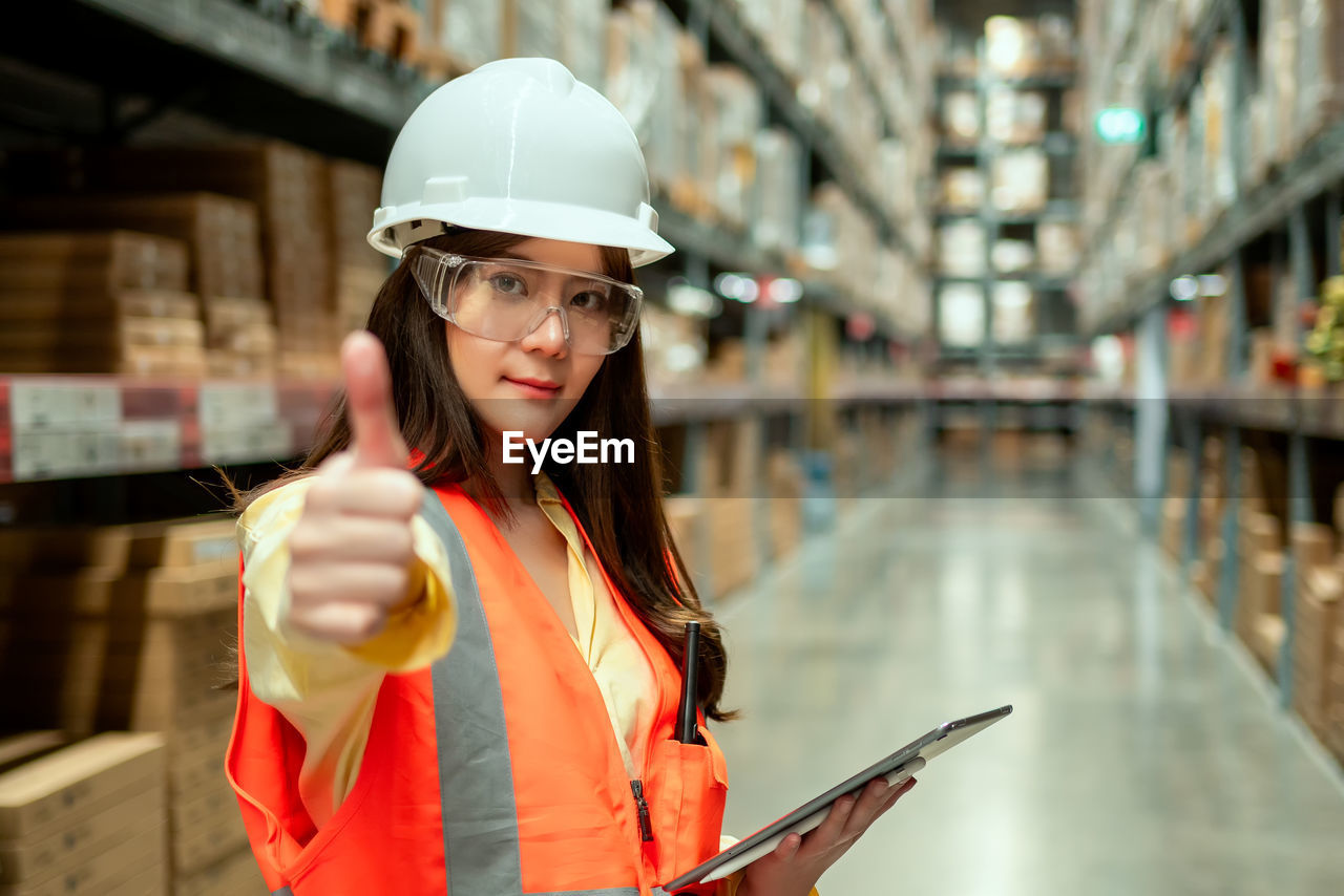 Female warehouse worker inspecting a warehouse in a factory. 