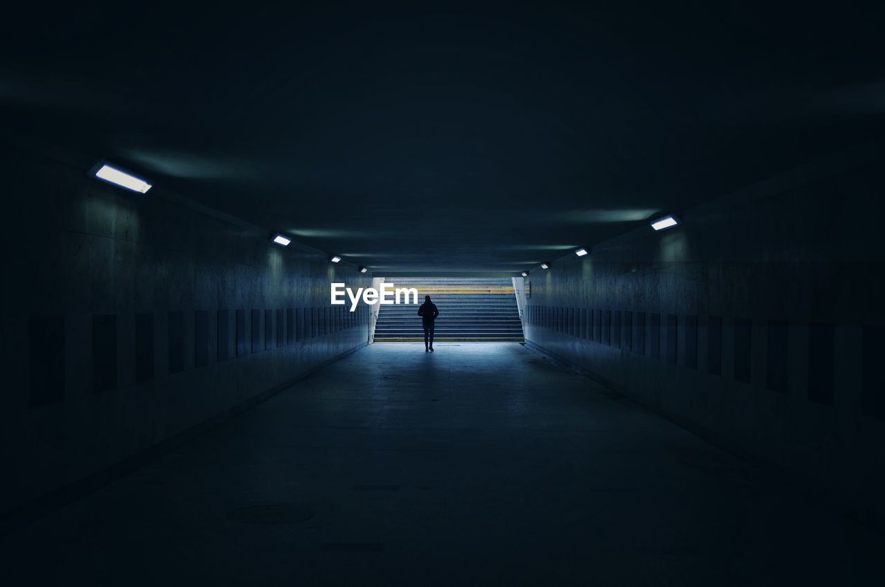 Interior of tunnel. man walking towards the light.