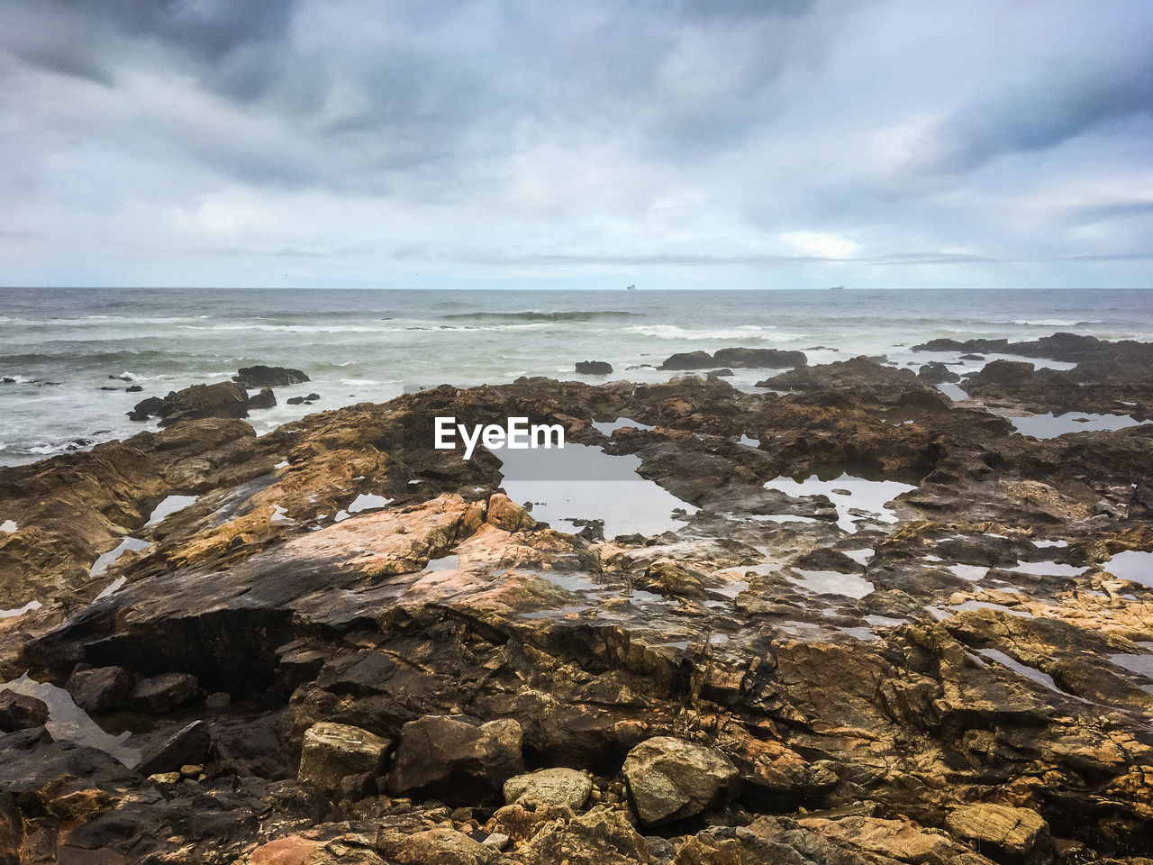 Rocks on beach against sky