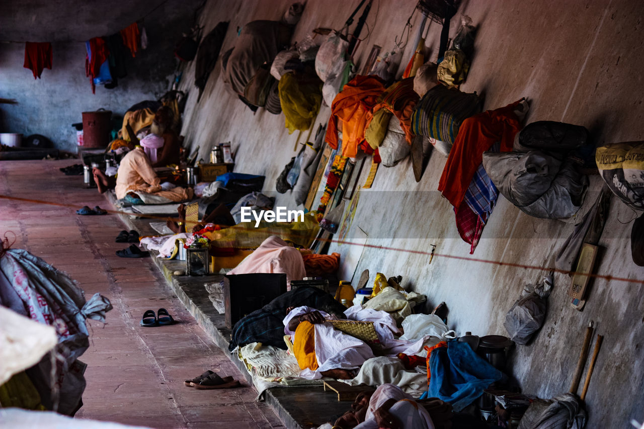 HIGH ANGLE VIEW OF PEOPLE HANGING ON FLOOR IN GARBAGE