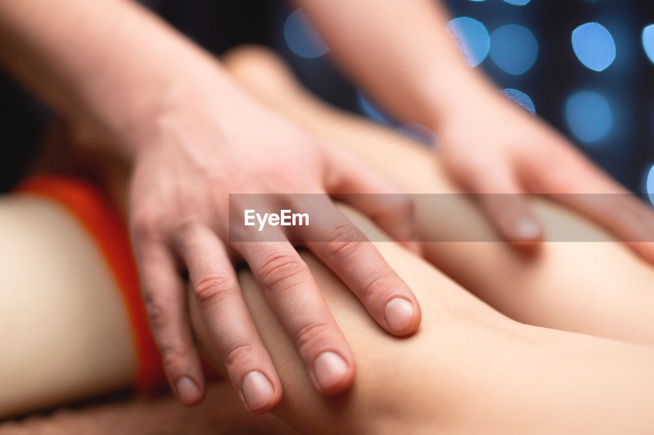 Massage stroking the ankle muscles in a professional office in a shallow depth of field.