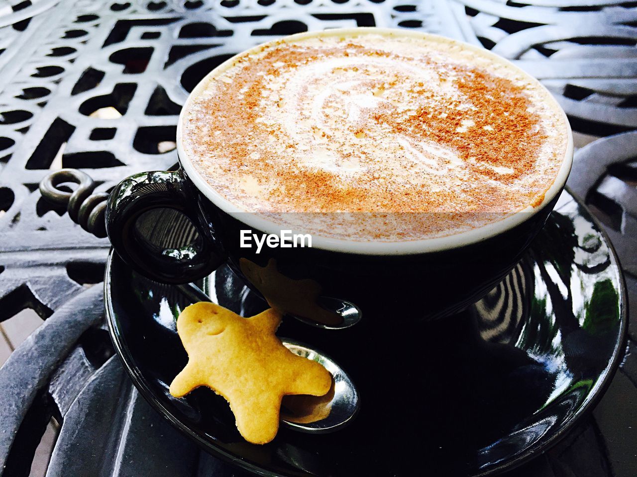 Close-up of served cappuccino coffee cup with cookie