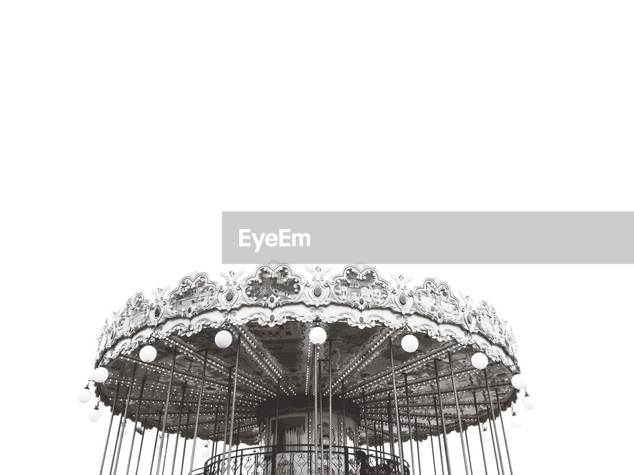 Low angle view of carousel in amusement park against sky