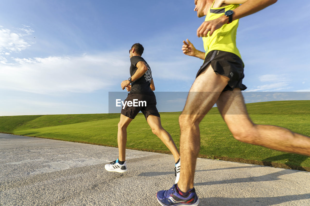 FULL LENGTH SIDE VIEW OF MAN RUNNING ON GRASSLAND