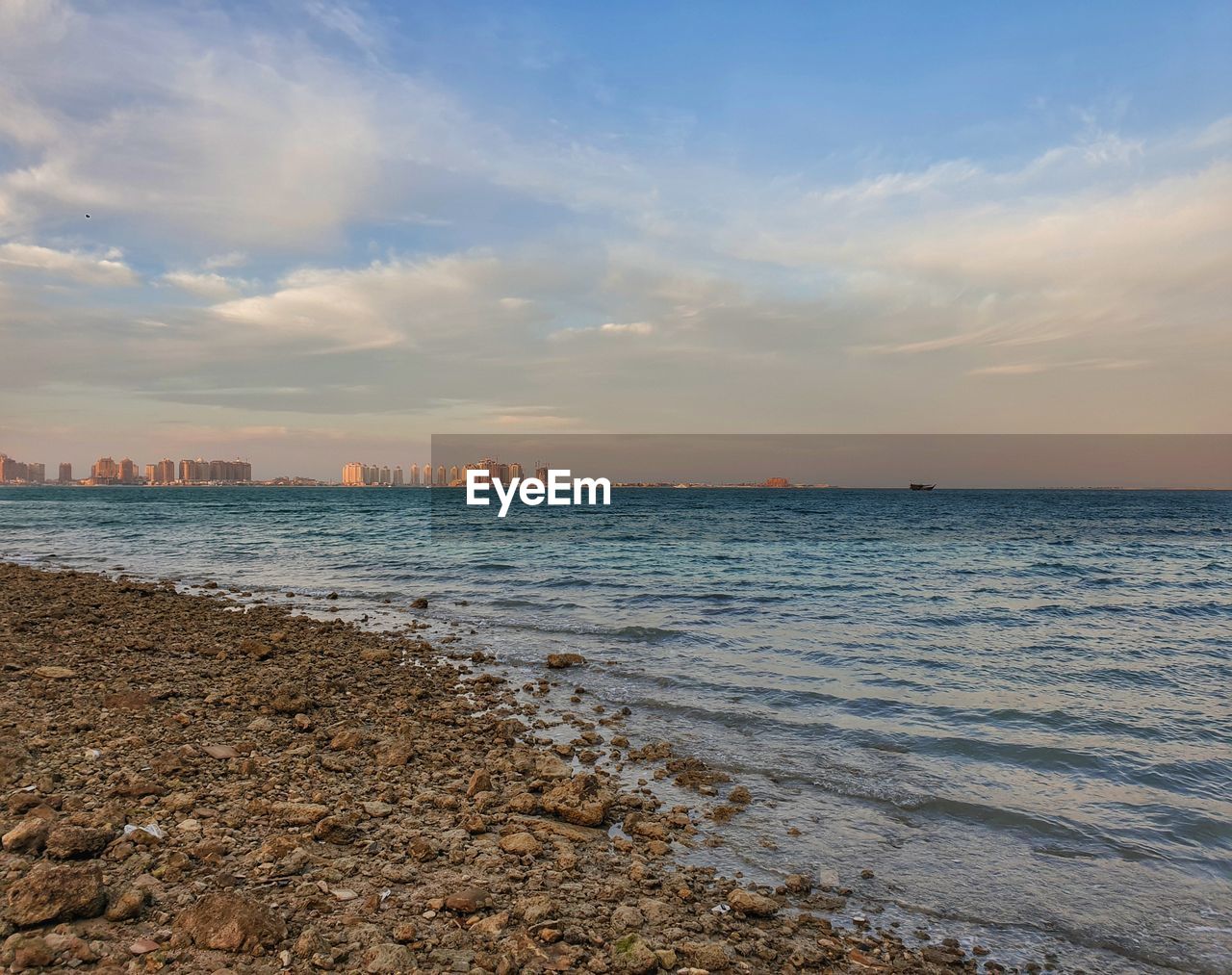 SCENIC VIEW OF BEACH AGAINST SKY AT SUNSET