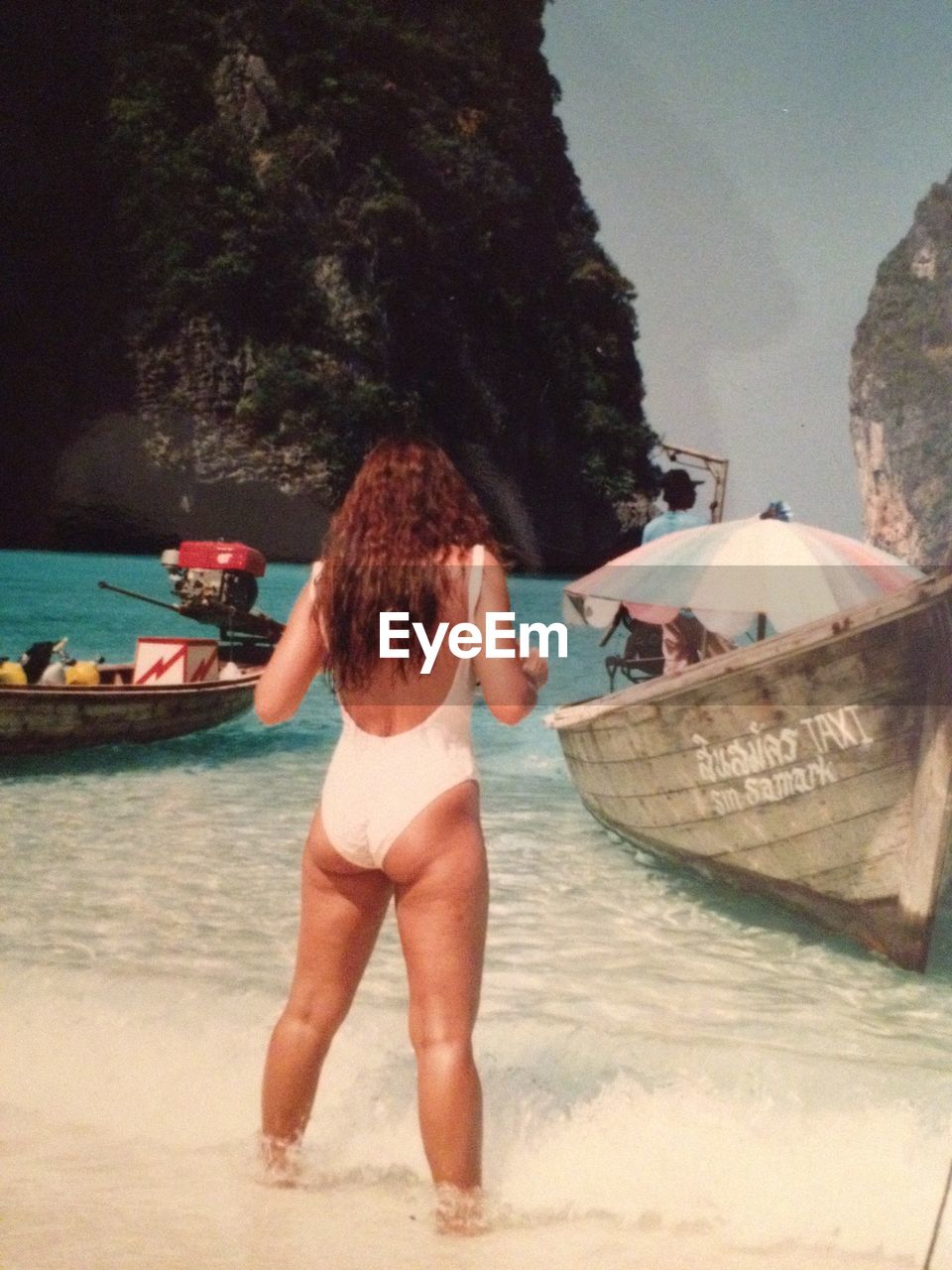 Rear view of woman in swimwear while standing against cliff at phi phi islands