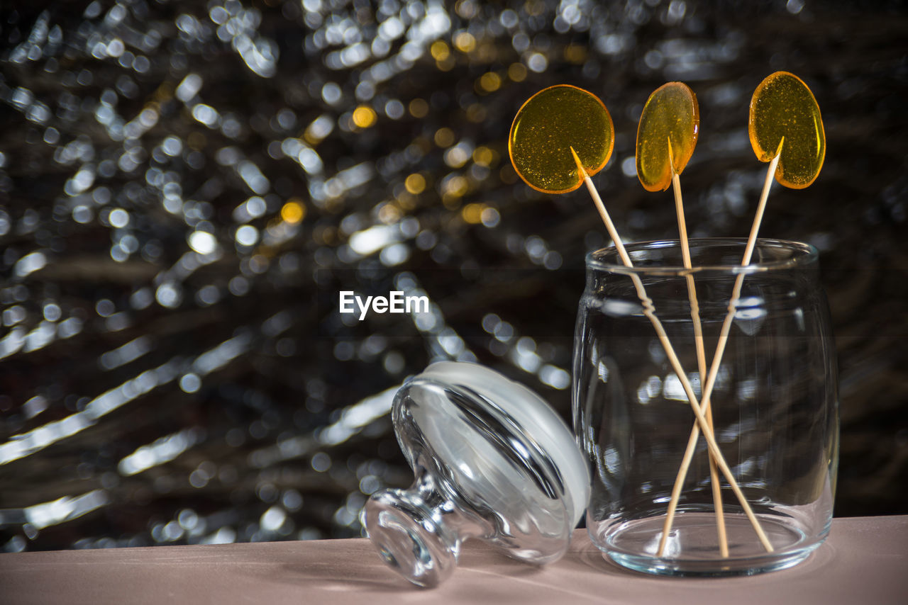 CLOSE-UP OF GLASS OF WATER ON TABLE AGAINST WALL