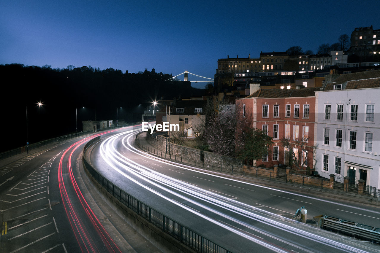 Light trails on road against sky at night