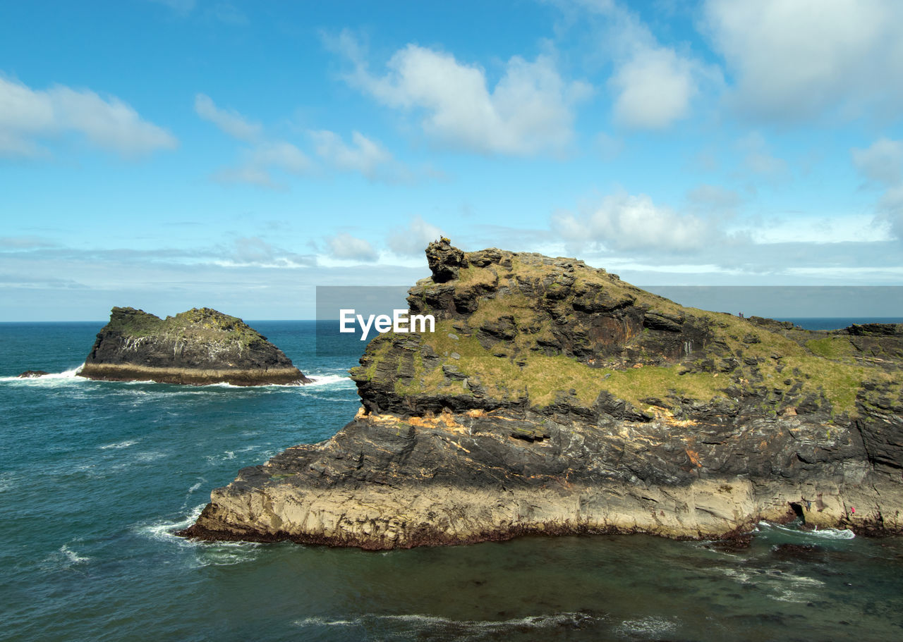 Scenic view of rocks in sea against sky