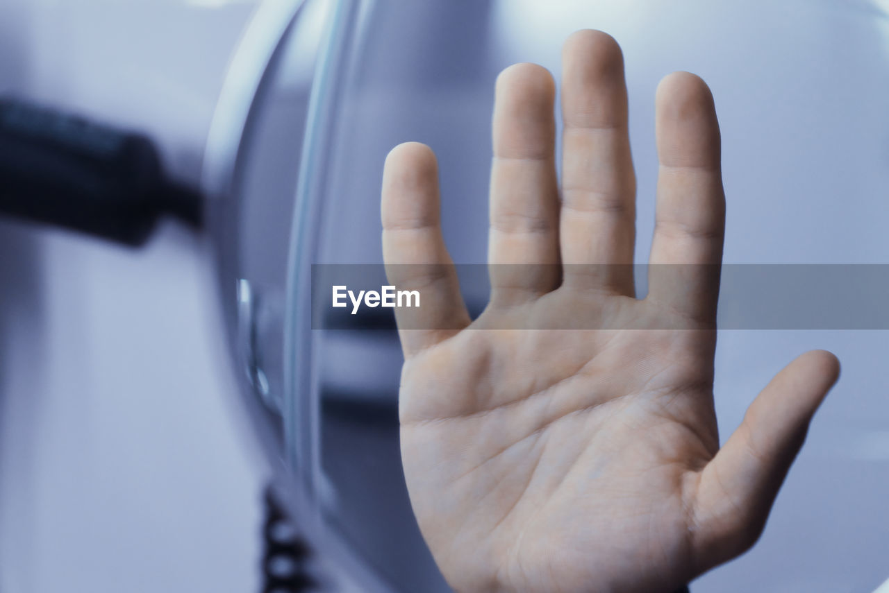 Close-up of human hand in bathroom showing stop gesture