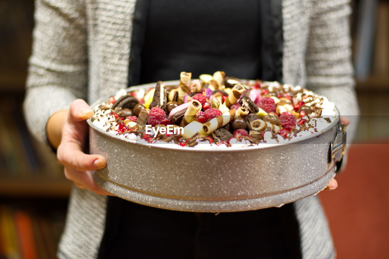 Midsection of woman holding decorated cake