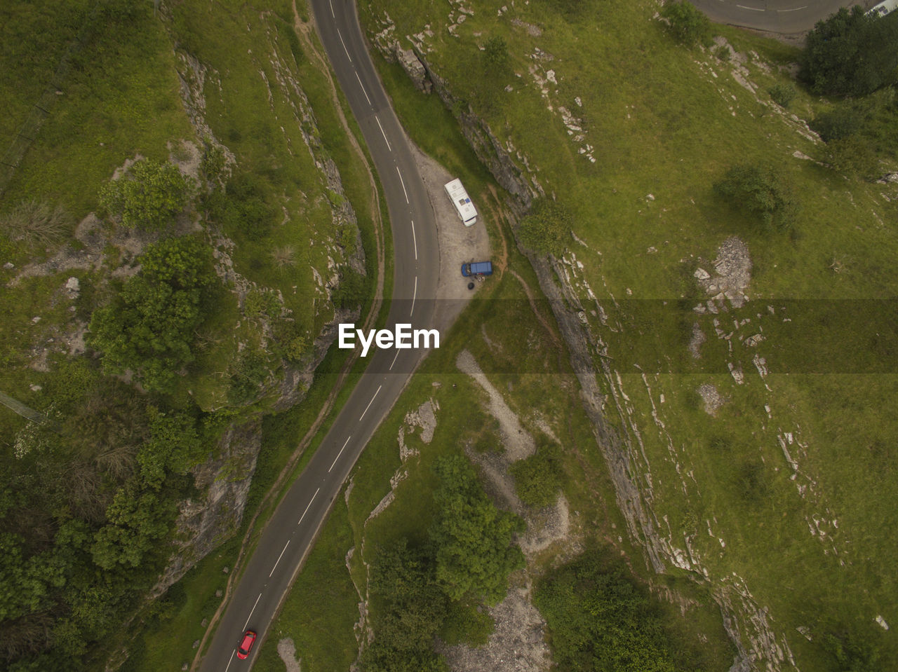 HIGH ANGLE VIEW OF ROAD ALONG TREES