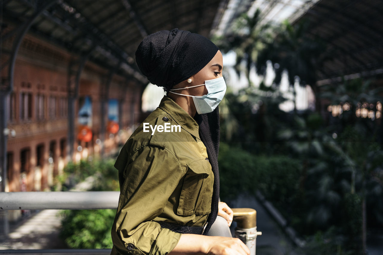 Portrait of modern muslim woman on a train station wearing a face mask