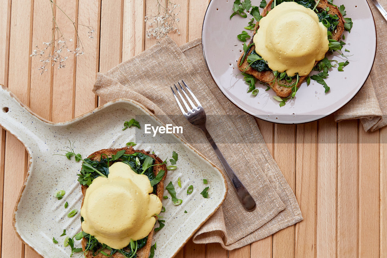 Vegan alternative eggs benedict with plant-based sauce, sourdough bread, tofu, onion,  pea sprout. 