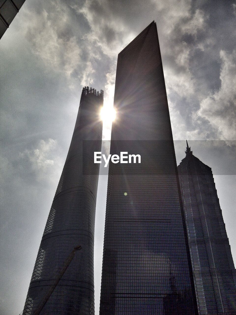 Low angle view of skyscrapers against cloudy sky