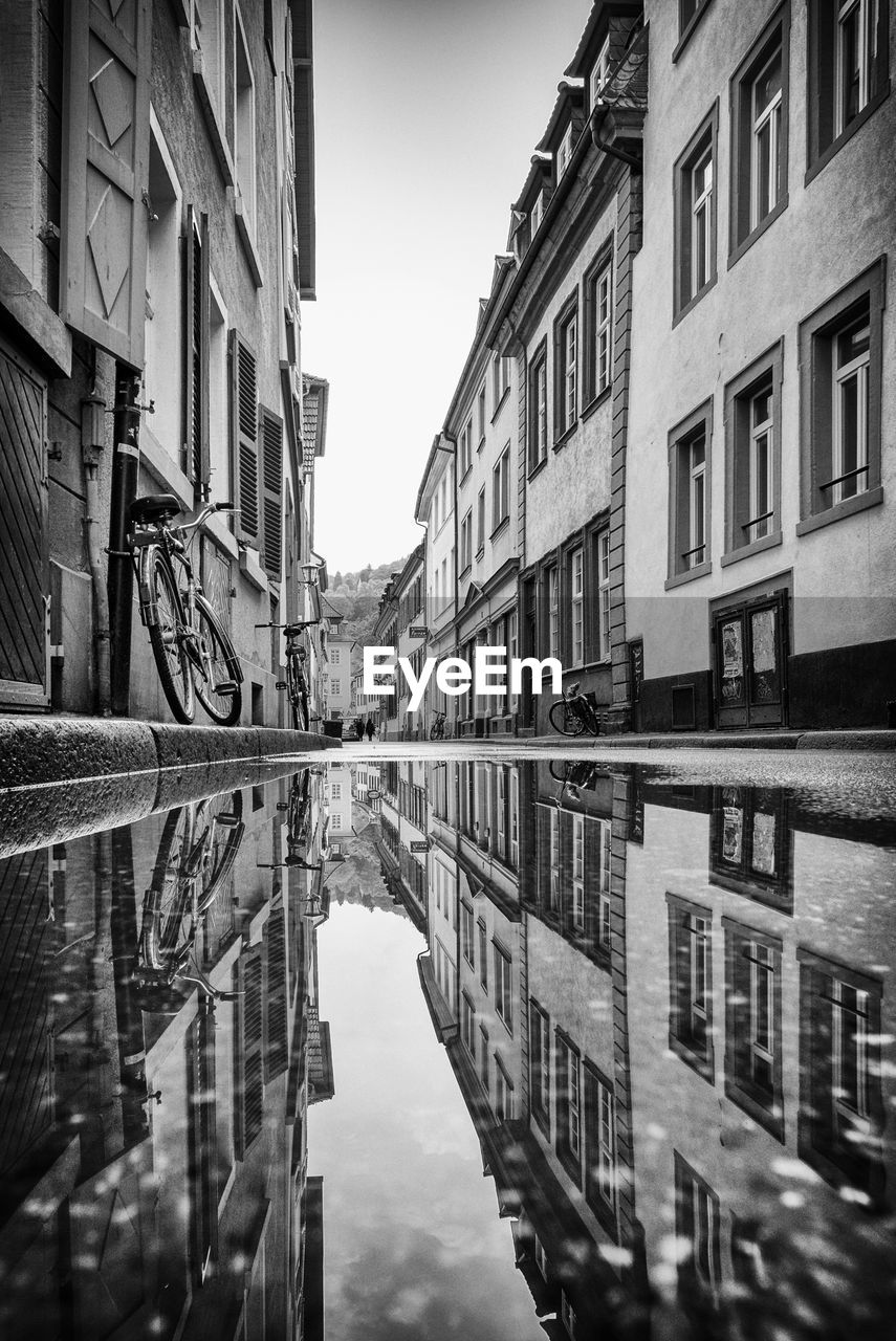 Reflection of buildings in canal against sky