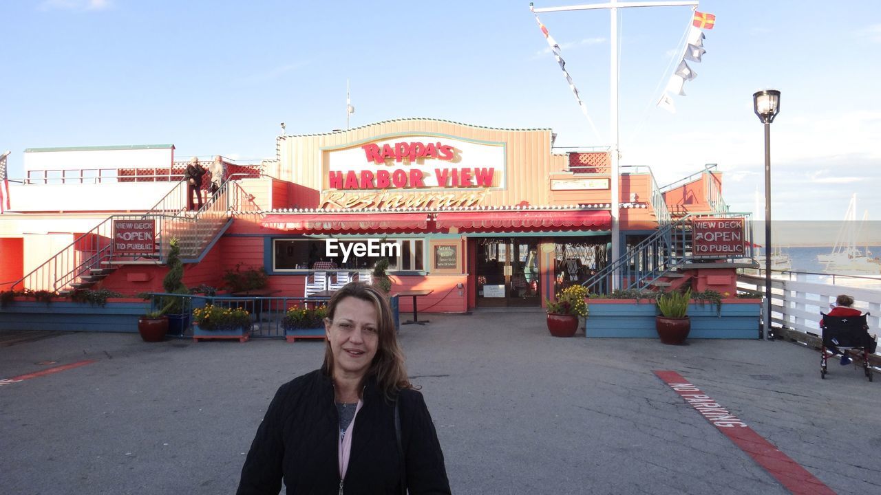 WOMAN STANDING IN FRONT OF BUILDING